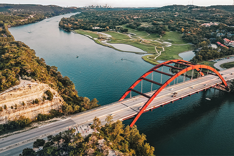 Veduta aerea di un fiume e di un ponte ad Austin, Texas, con la città sullo sfondo.