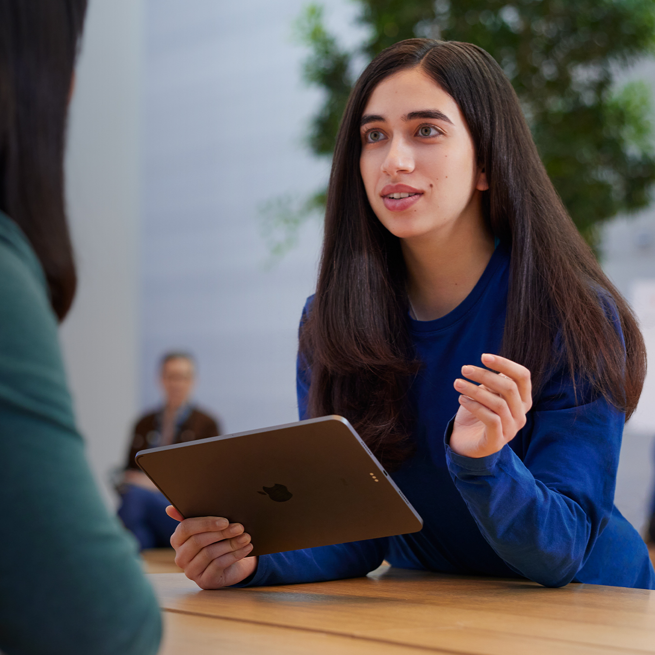 Serene staat met een iPad in haar hand met een klant te praten.