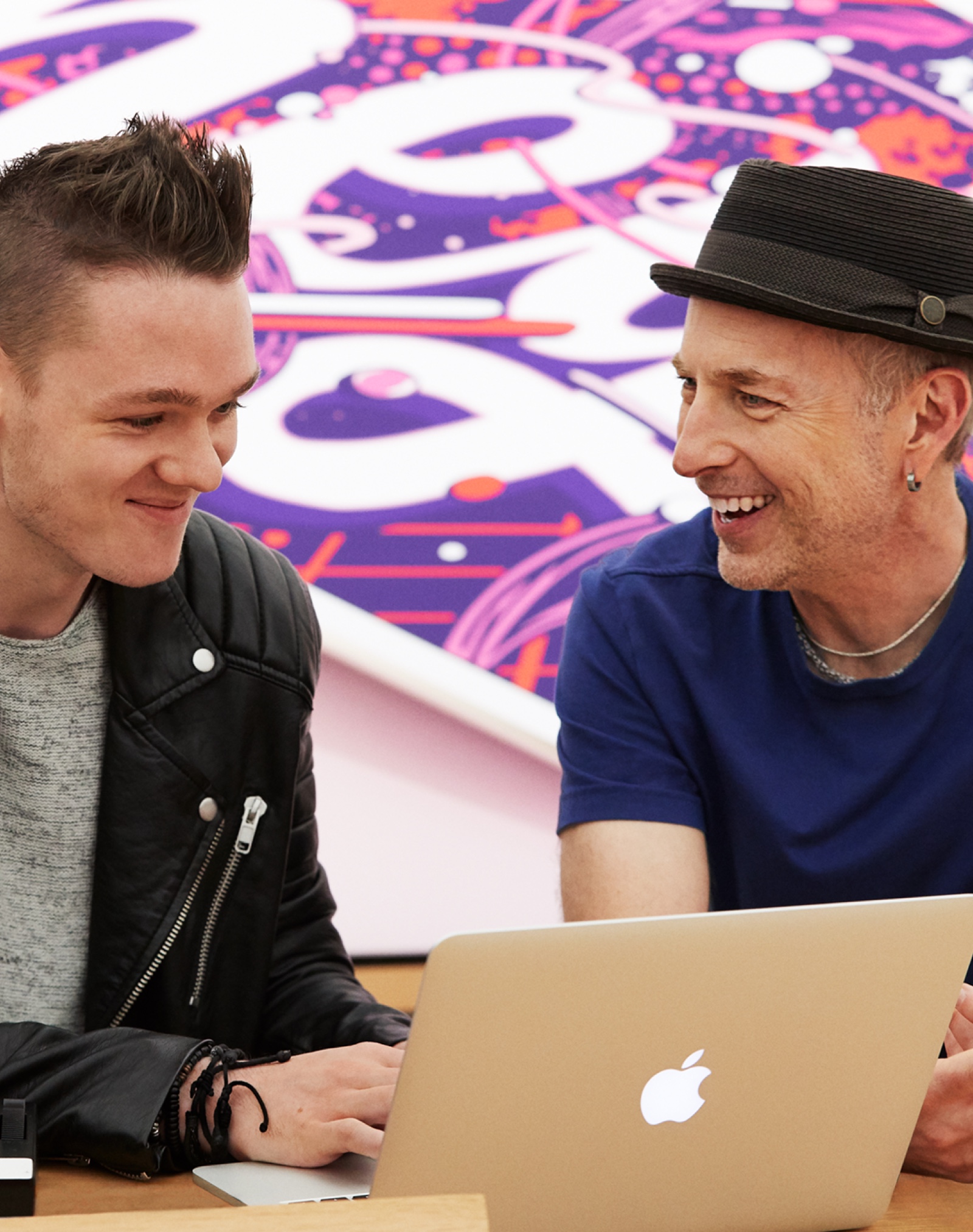 Apple Store에서 남성 직원이 Mac으로 음악을 만드는 고객을 도와주는 모습