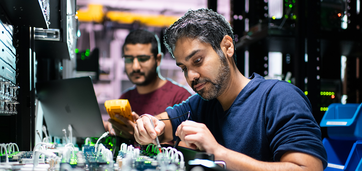 Deux ingénieurs Apple travaillent dans un laboratoire sur les composants d’un iPhone.