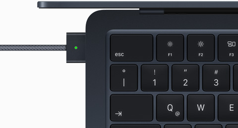 Imagen desde arriba de un cable MagSafe conectado a un MacBook Air color medianoche