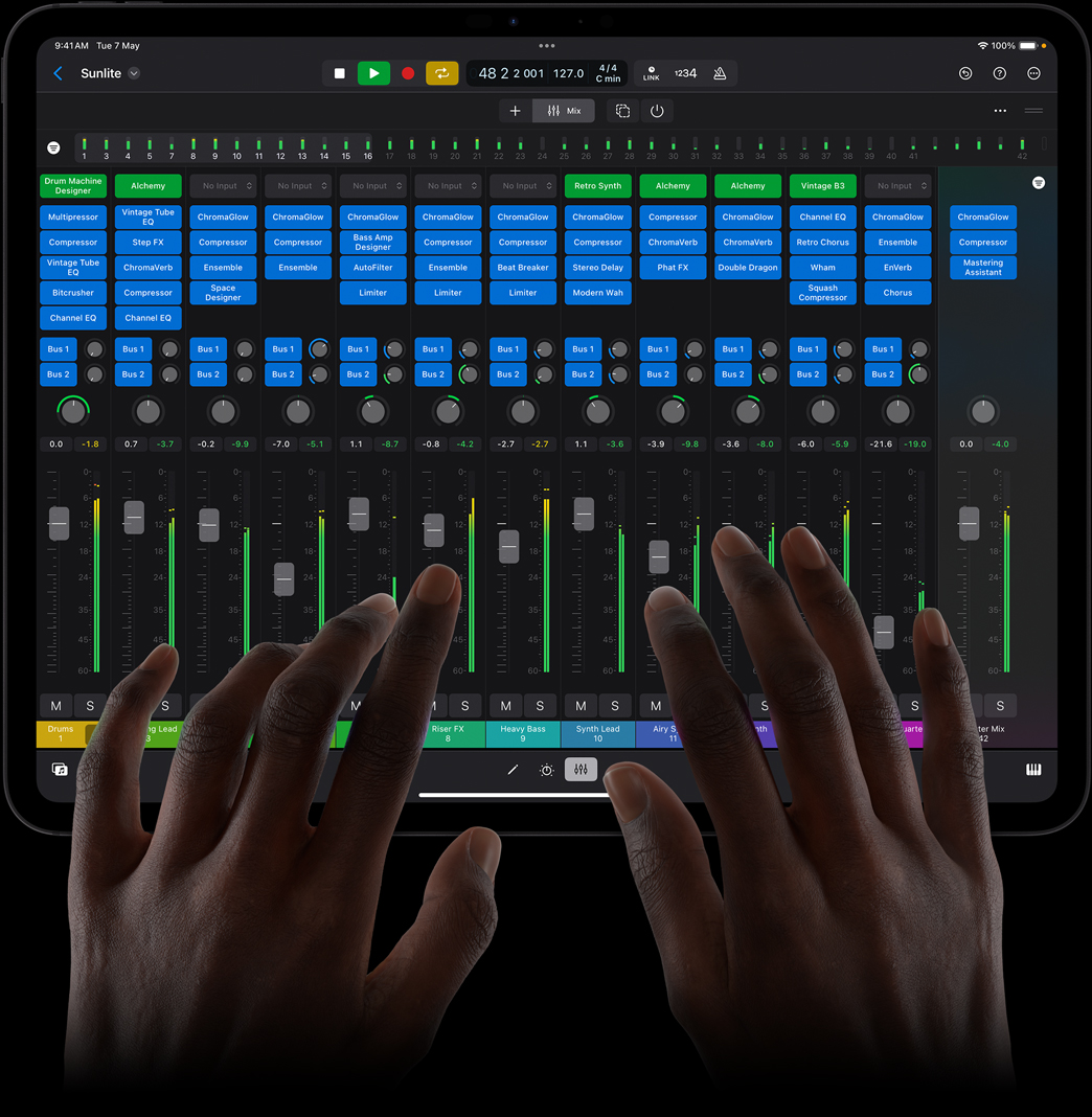 Hands touching an iPad Pro using a full-featured mixing console on Logic Pro for iPad.