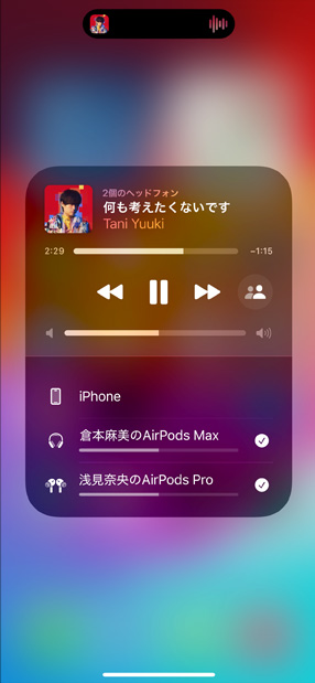 充電ケースに入ったAirPods ProがiPhoneの隣にある。iPhoneは2組のAirPodsに接続されており、それぞれの音量調節が表示されている。