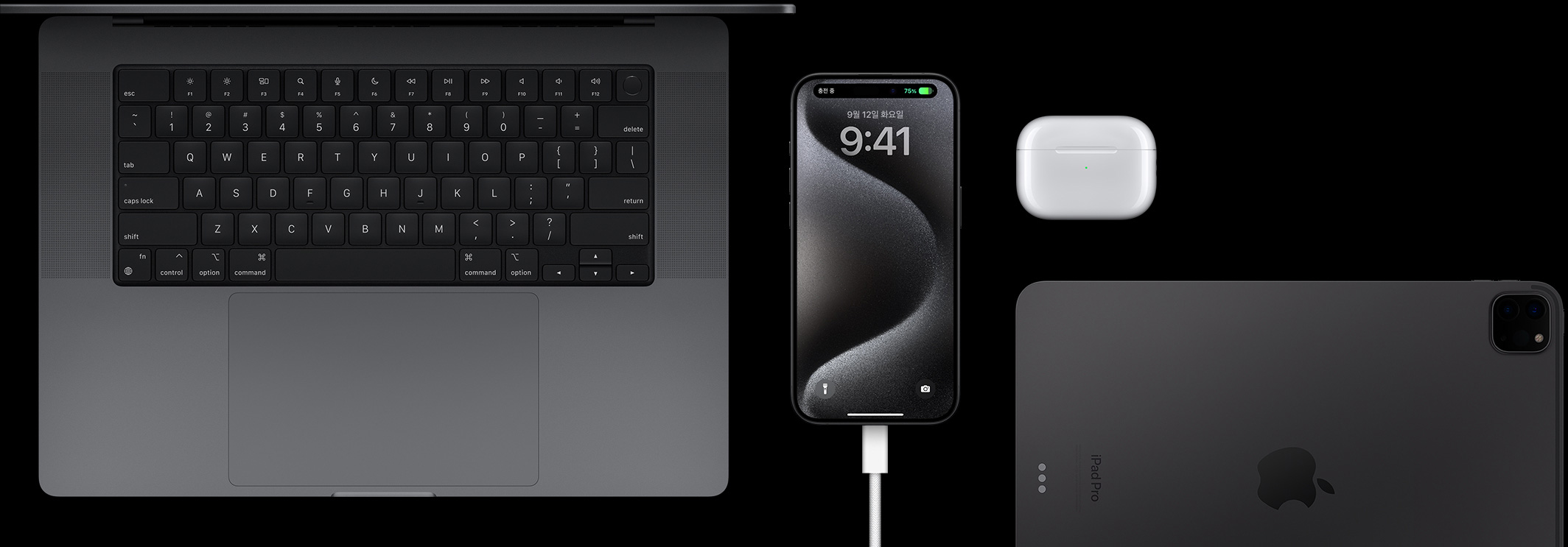 USB-C 케이블이 연결된 iPhone 15 Pro 주변에 Macbook Pro, AirPods Pro, iPad를 함께 놓아둔 모습