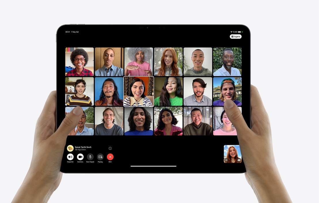 Bir çift el, ekranında FaceTime görüntülü grup araması gösterilen bir iPad Pro tutuyor.