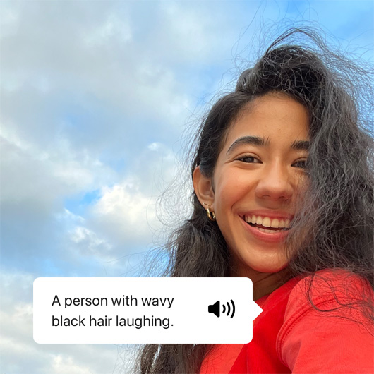 VoiceOver describing a photo and showing speech output. ‘A person with wavy black hair laughing.’