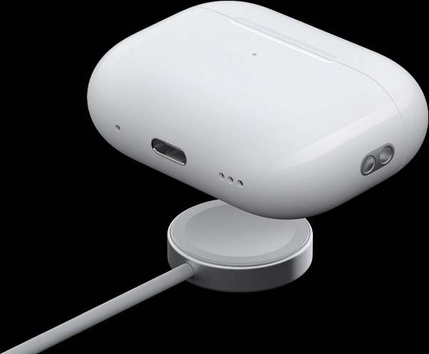 Vue de trois quarts du boîtier de charge MagSafe mettant en évidence le haut-parleur, la boucle pour dragonne et le port USB-C, le boîtier surplombe la rondelle de charge de l’Apple Watch.