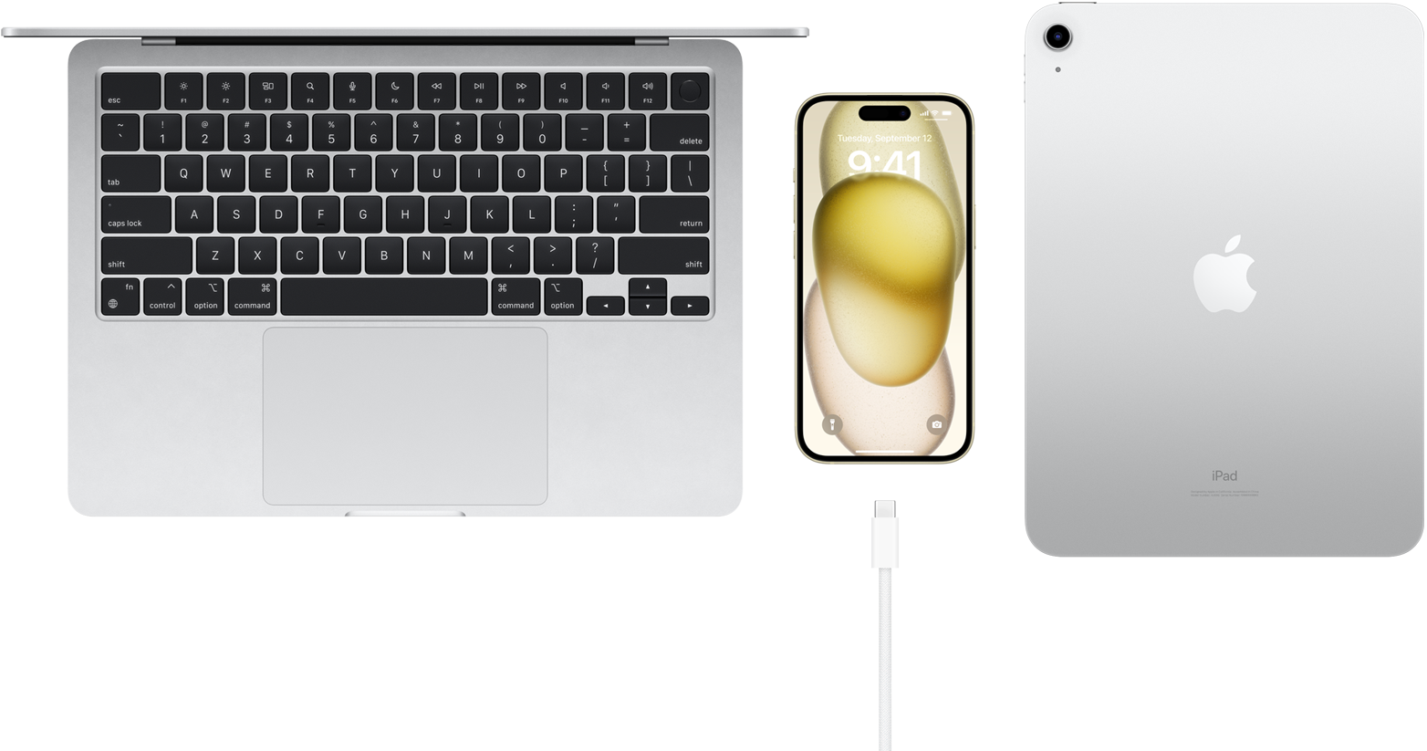 Pohled shora na MacBook Pro, iPhone 15 s USB‑C konektorem a iPadem