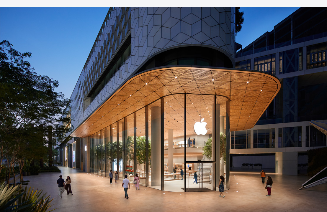 Fotografia przedstawiająca nowoczesny sklep Apple nocą.