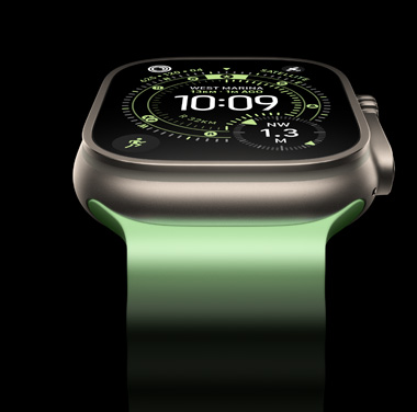 A close-up of a Natural Titanium Apple Watch Ultra 3 on a black background. The display shows the time and other dynamic info.