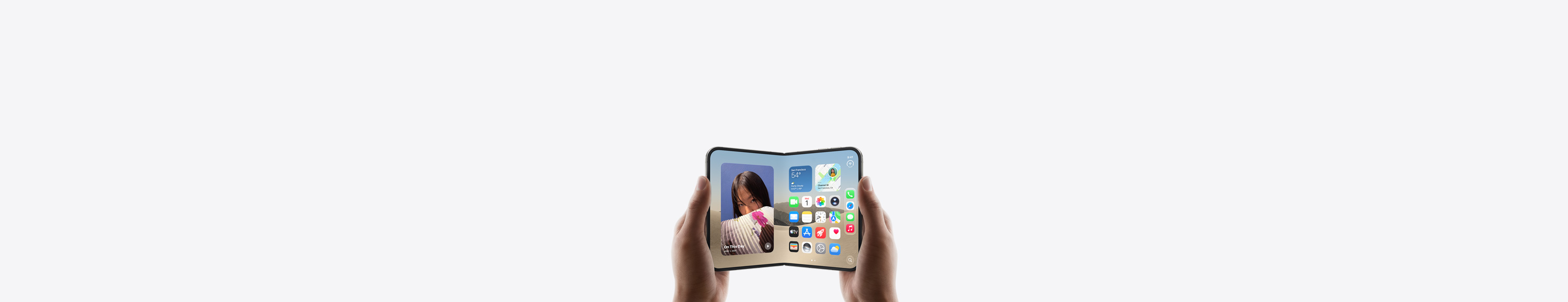 Duas mãos seguram um iPhone Duo na horizontal, mostrando a Tela de Início na tela interna