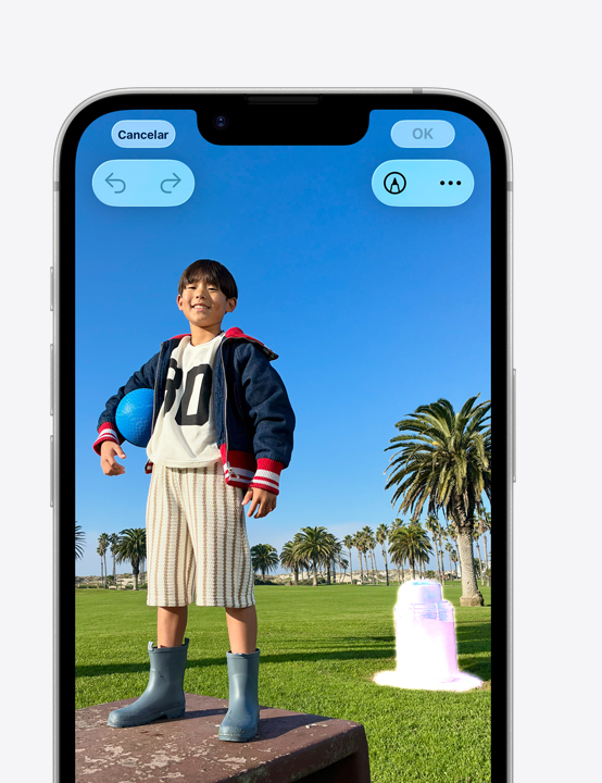 Tela do iPhone, com a foto de uma pessoa sorrindo no parque, mostra como remover uma lixeira ao fundo com a ferramenta de Limpeza
