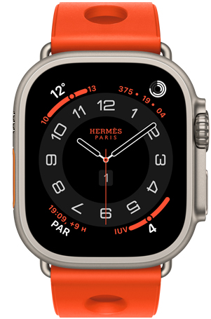 Apple Watch Hermès Ultra 3, cadran analogique Circulaire (aiguilles pour les heures, les minutes et les secondes; complications : météo, anneaux d’activité, heure de Paris, indice UV); boîtier en titane, naturel, côté droit extérieur, couronne Digital Crown, bouton latéral surélevé; jumelé à un bracelet Scub’H Diving, orange néon (orange vif), en caoutchouc moulé, découpes circulaires centrées