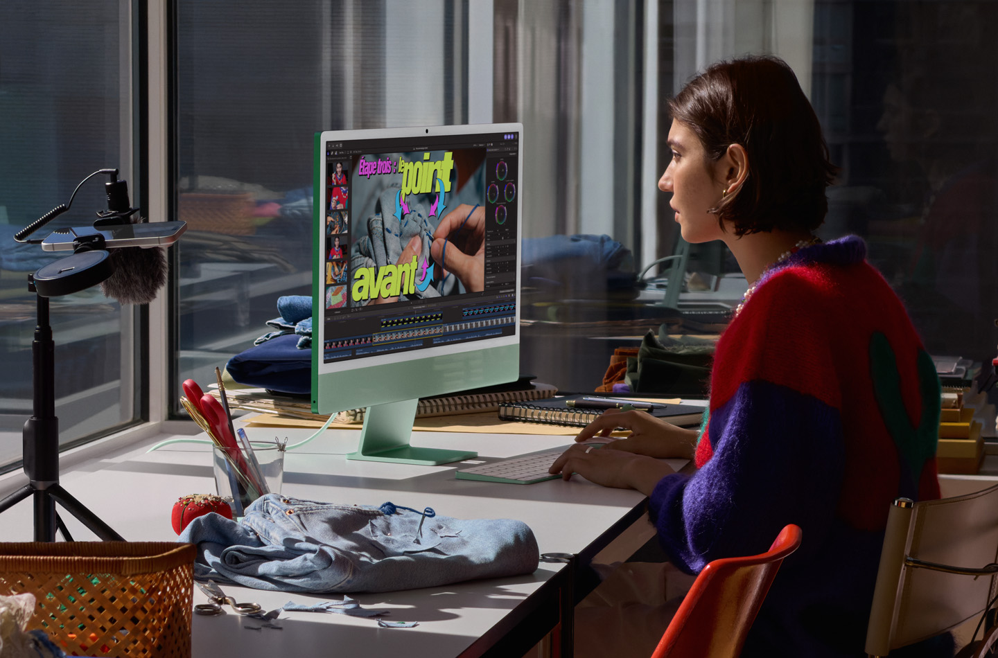 Personne assise à un bureau travaillant sur un iMac vert, tapant sur un Magic Keyboard, utilisant une Magic Mouse et regardant un tutoriel de couture