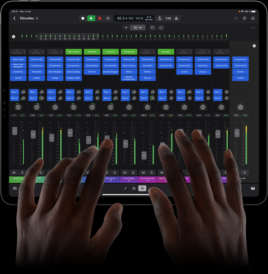 Des mains touchent un iPad Pro pour utiliser une console de mixage complète dans Logic Pro pour iPad.