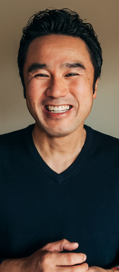 Yüzünde büyük bir gülümsemeyle kameraya bakan Tetsu’nun portre fotoğrafı.