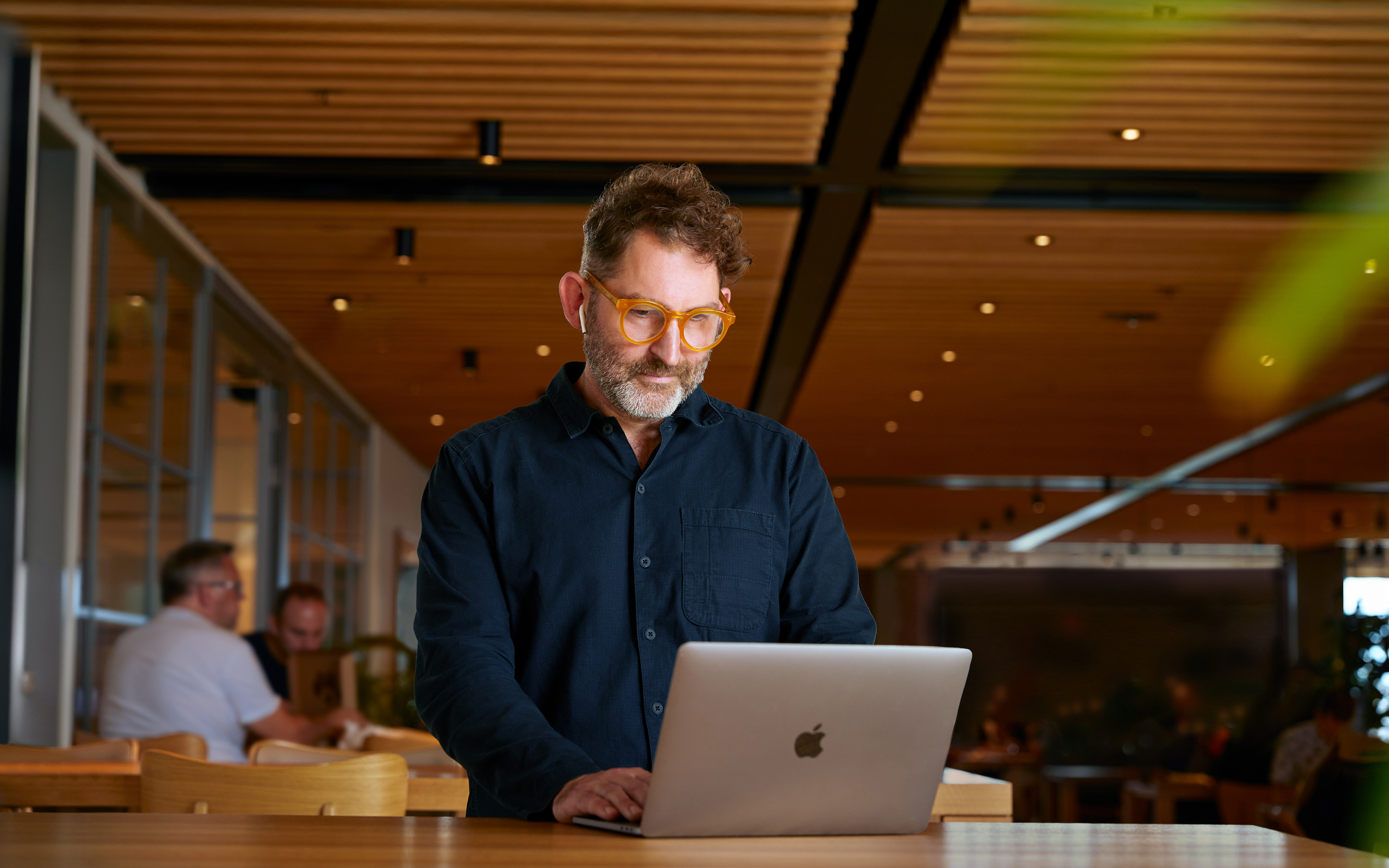 Ein Apple Corporate Teammitglied arbeitet in einem Caffè Macs an einem MacBook.