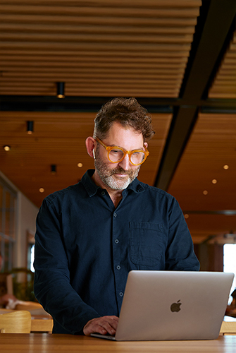 Ein Apple Corporate Teammitglied arbeitet in einem Caffè Macs an einem MacBook.