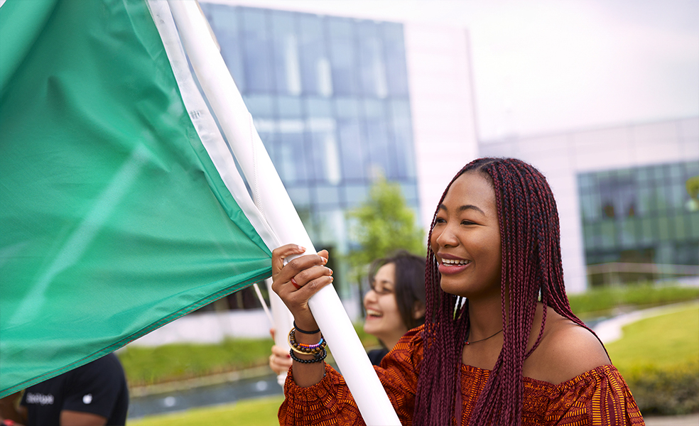 موظفة في مقر Apple بكورك تسير حاملة علماً.