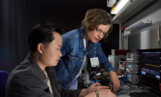 Ruth 在實驗室工作檯與一位同事合作研究晶片技術。