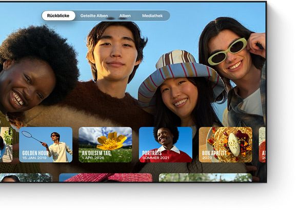Fotos App auf dem Fernseher, Tab „Rückblicke“ ausgewählt, vier lächelnde Personen, Reihe mit datierten Miniaturbildern von Rückblicken darunter