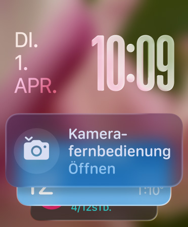 Das Widget für die Kamera Fernbedienung wird unten auf dem Bildschirm angezeigt, transluzente Zeitziffern oben rechts, Datum oben links