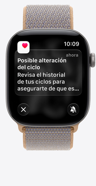 Apple Watch Series 12, la pantalla muestra Control del Ciclo en la app Salud, notificación de posible alteración del ciclo, caja de aluminio, color gris espacial, con correa Loop deportiva, color azul chambray (azul claro-gris)