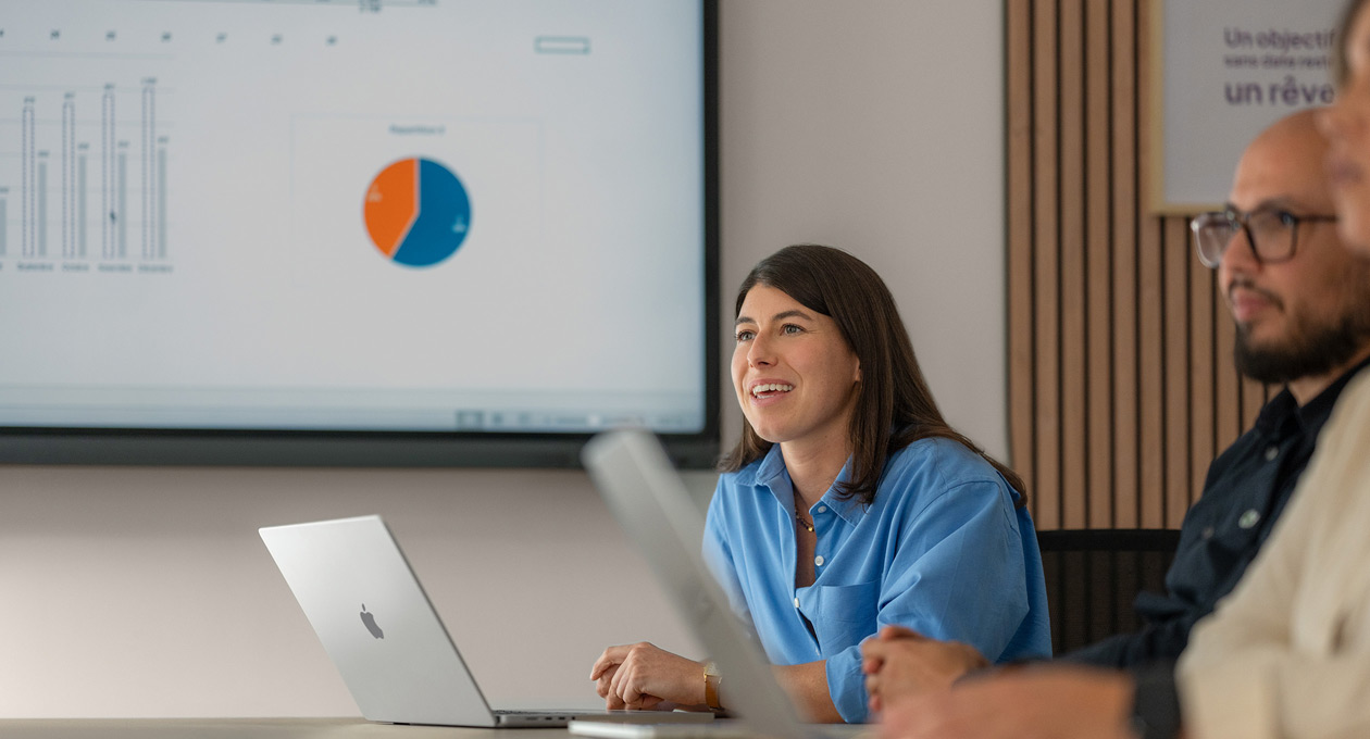 Employees in a meeting using MacBooks