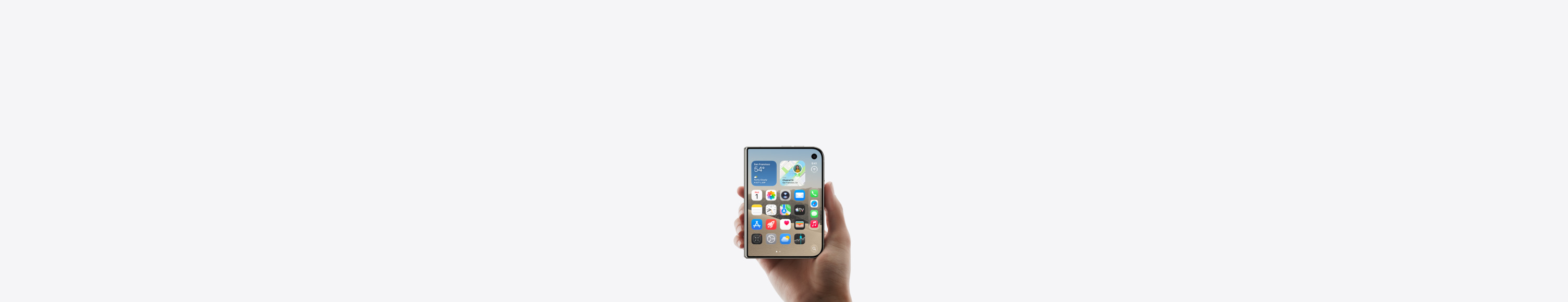 iPhone Duo, Star White colour, held by a hand in closed position, outer display shown, iOS home screen with apps and widgets.