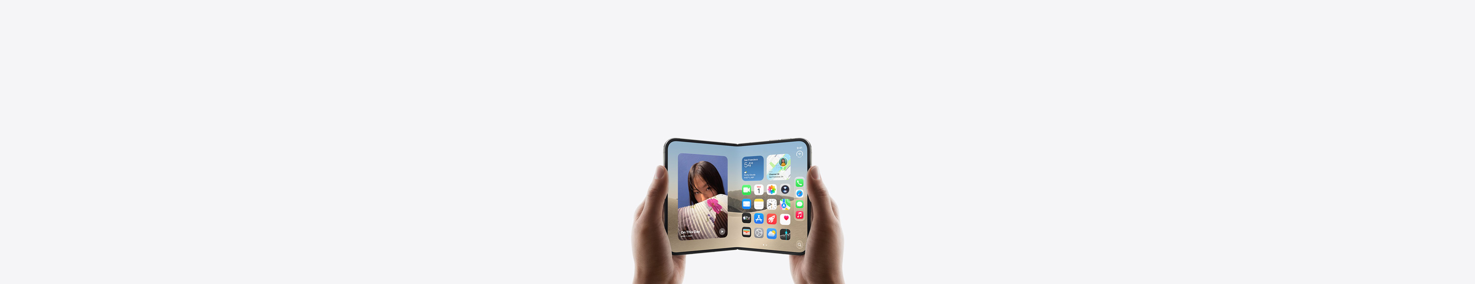 iPhone Duoa pidellään vaakasuunnassa kahdella kädellä, avattuna, sisäpuolen näytöllä Koti-valikko