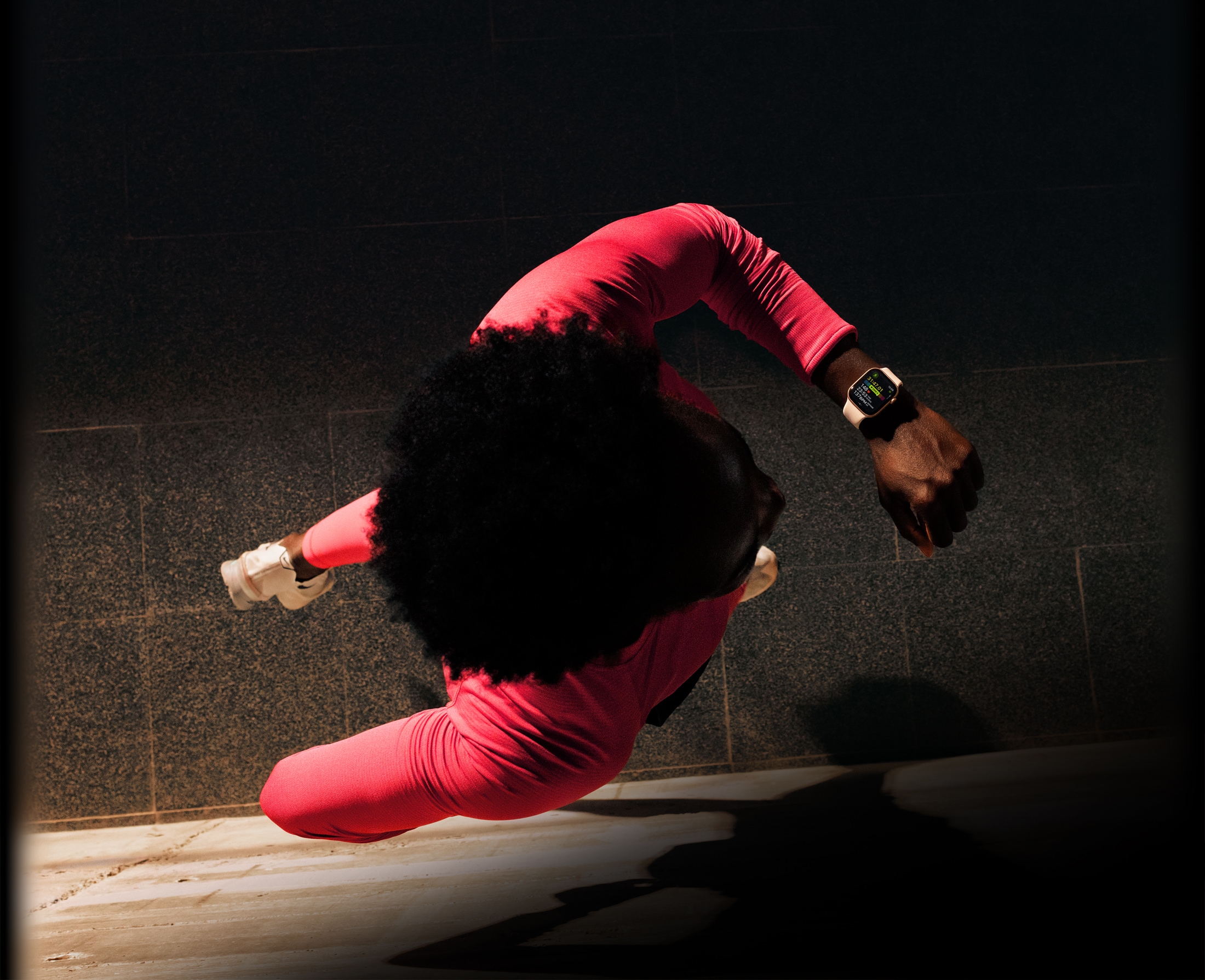 Valaki futás közben megnézi az edzésadatait az Apple Watch Series 11 Edzés alkalmazásában