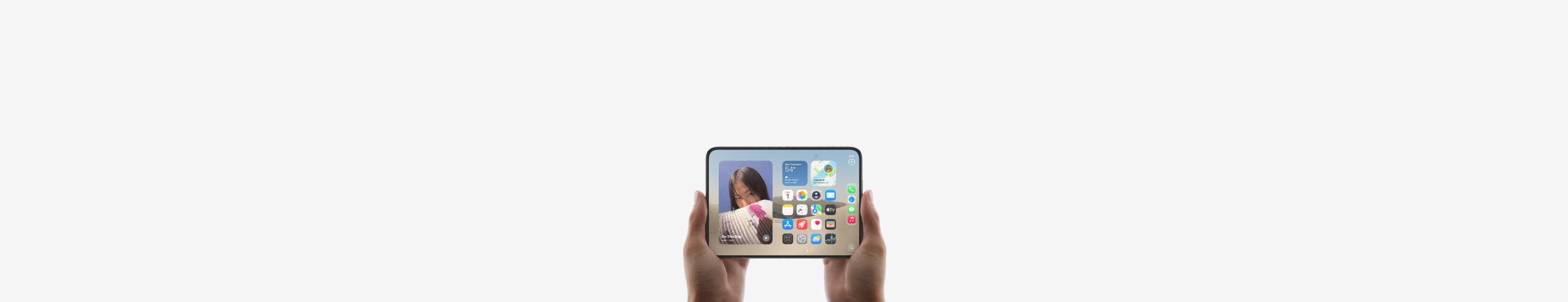 iPhone Duo, Star White színben, kézben tartva, összecsukott állapotában, a külső kijelző látható, iOS főképernyő alkalmazásokkal és widgetekkel.