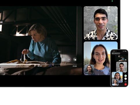 Mac and iPhone: SharePlay split view on Mac, Apple TV show plays on left, FaceTime tiles on right show three people, iPhone mounted beside Mac used as Continuity Camera