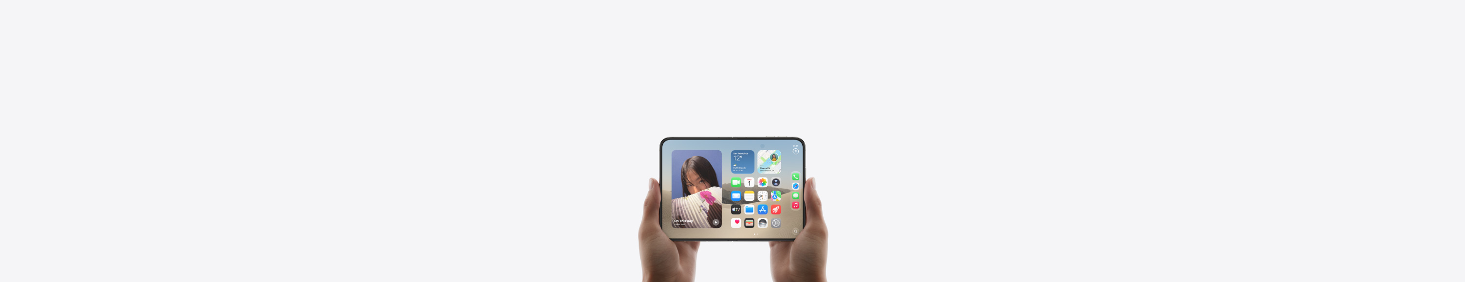 iPhone Duo, Star White color, held by a hand in closed position, outer display shown, iOS home screen with apps and widgets.