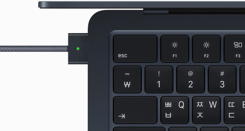 미드나이트 색상 MacBook Air에 연결된 MagSafe 케이블을 위에서 내려다본 모습