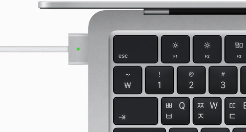 실버 색상 MacBook Air에 연결된 MagSafe 케이블을 위에서 내려다본 모습