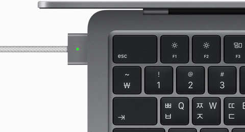 스페이스 그레이 색상 MacBook Air에 연결된 MagSafe 케이블을 위에서 내려다본 모습