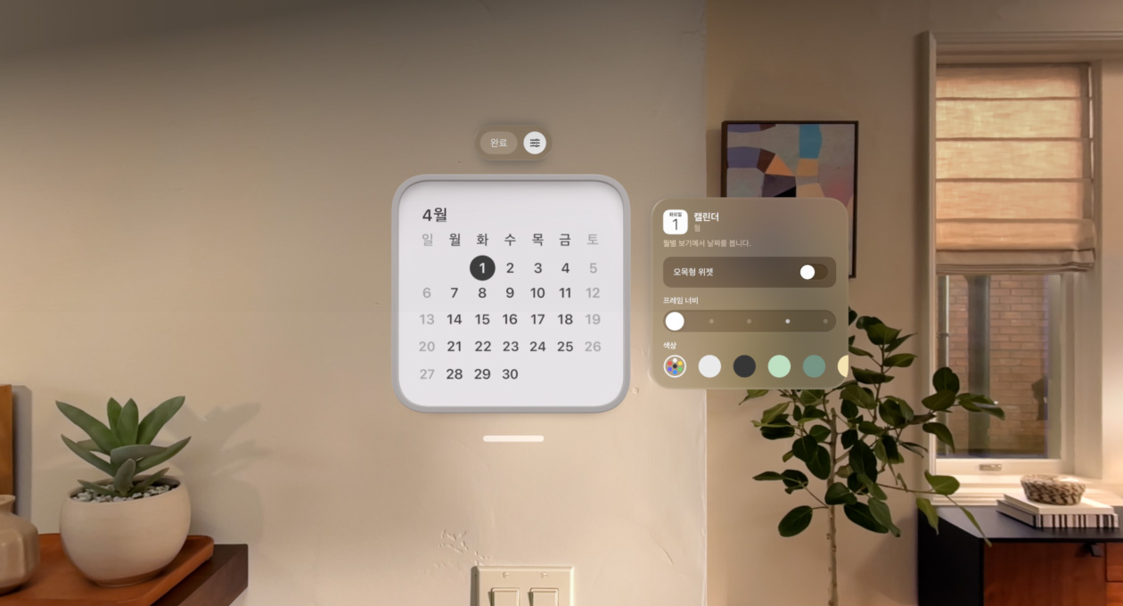 4월 1일이 표시된 캘린더 위젯이 벽 위에 떠 있고, 미리 알림 위젯이 상단에, 프레임의 두께와 색상을 변경하는 개인 맞춤화 옵션이 오른쪽에 떠 있는 모습