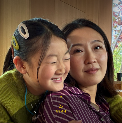 Naudojama „2x Telephoto“ funkcija, priartinamas dviejų apsikabinusių žmonių vaizdas