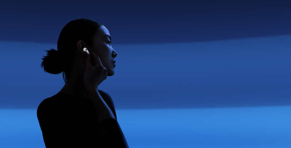 سيدة تضع إبهامها وسبابتها على جذع سماعة AirPods 5 لتغيير أنماط الاستماع