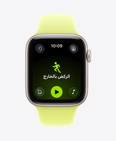 Apple Watch SE 3 بإطار من الألومنيوم بلون ضوء النجوم، وتمرين الركض بالخارج مفتوح، وعناصر التحكم في التشغيل داخل تطبيق Apple Music في أسفل الشاشة، وحزام رياضي بلون أصفر نيون