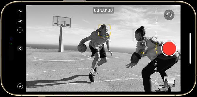 An iPhone 14 Pro screen containing a black and white Cinematic mode still of two people playing basketball.