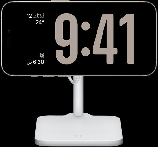 iPhone 15 Pro‏ في نمط الاستعداد يعرض الساعة في وضع ملء الشاشة والتاريخ ودرجة الحرارة والمنبه المضبوط التالي
