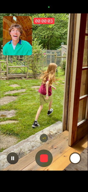 شاشة iPhone 17 تستخدم ميزة التقاط الفيديو بالكاميرا الأمامية والخلفية لفتاة صغيرة تركض بينما يشاهدها رجل