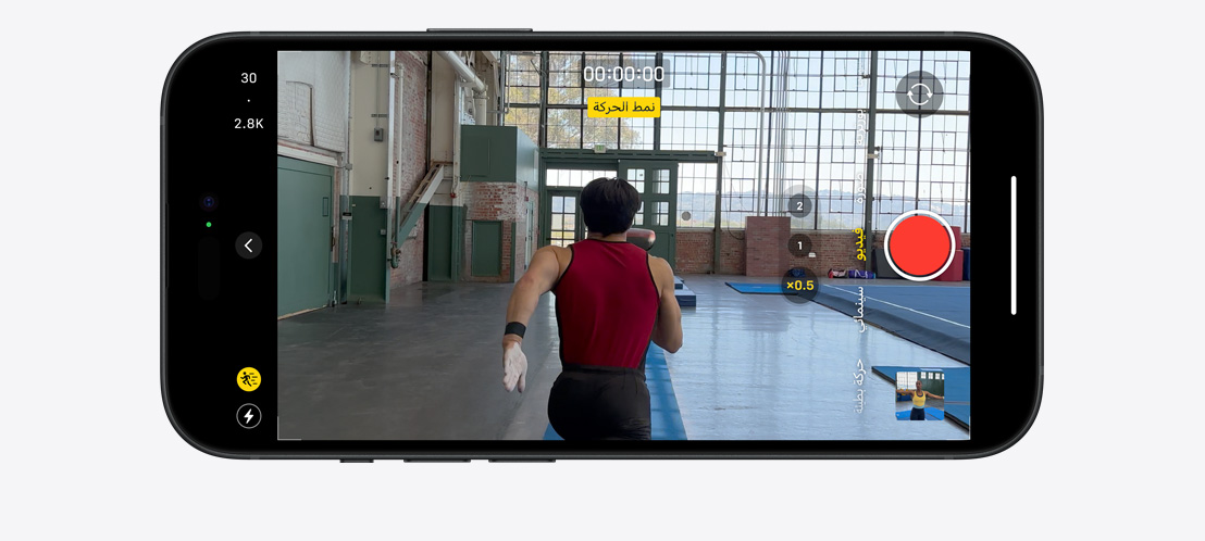 صورة لجهاز iPhone 15 Pro يصوّر مقطع فيديو في نمط الحركة للاعب جمباز يركض داخل غرفة واسعة مليئة بالإضاءة.