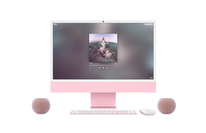 Parte frontal de una iMac rosa, Apple Music reproduciendo música en la pantalla, Magic Keyboard y Magic Mouse del mismo color, junto a dos bocinas HomePod mini 2 rosas formando un par estéreo