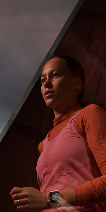 Bileğindeki Apple Watch Series 9’da Koşu antrenmanını takip eden bir kadın.