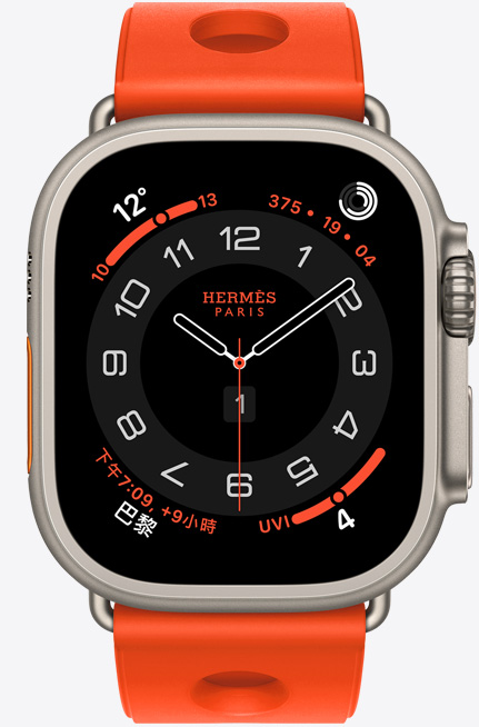 原色鈦金屬錶殼 Apple Watch Hermès Ultra 3，採用 Circulaire 指針錶面 (小時、分鐘與秒針，以及多項複雜功能，包括天氣、活動記錄圓圈、巴黎時間與紫外線指數)，右側外觀上有數位錶冠和凸起的側邊按鈕，搭配 Orange Néon 霓虹橙色 (亮橙色) Scub’H Diving 錶帶，錶帶由橡膠材質模塑成型，中央有圓孔鏤空設計