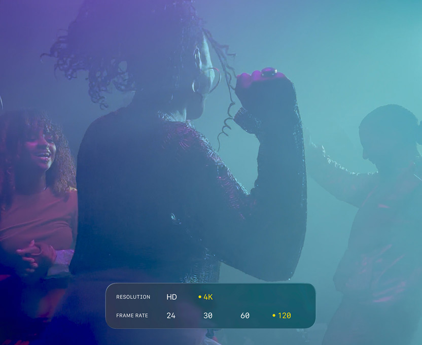 A screen of three people dancing in low-light filming conditions shows the capabilties of 4K 120 fps Dolby Vision