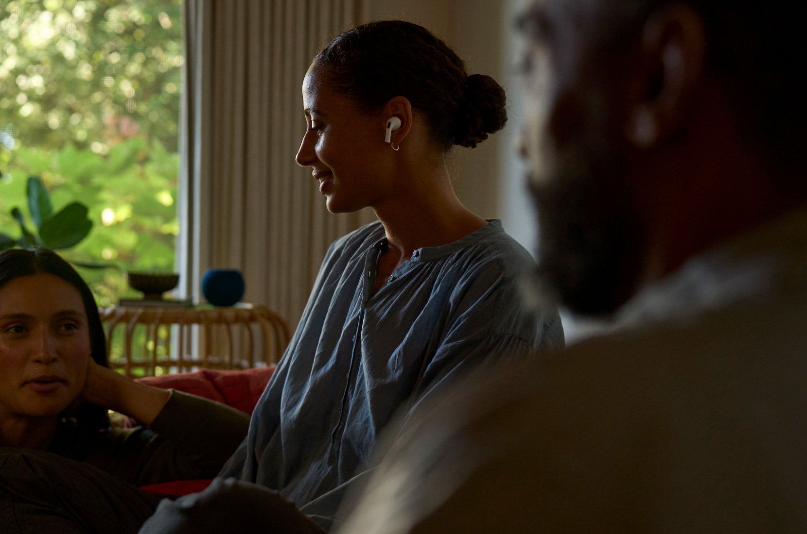 Foto van het zijprofiel van een vrouw met AirPods Pro 2 in het linkeroor die gebruik maakt van de feature Gehoorgezondheid